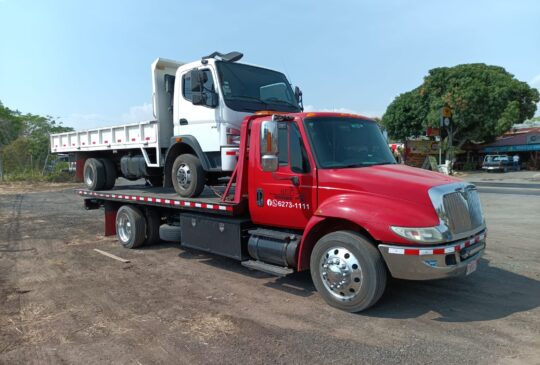Grúa de plataforma de Grúas Alajuela cargando un camión de volquete