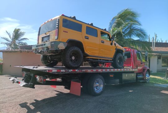 Vehículo todoterreno amarillo cargado en la grúa cerca de la costa
