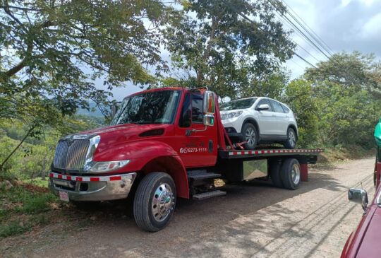 Grúa atendiendo un vehículo averiado en carretera de montaña