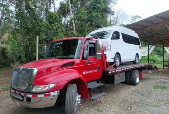 Grúa de Grúas Alajuela con una buseta blanca cargada en la plataforma